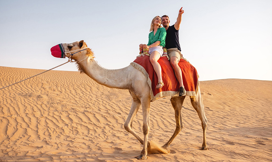 Guests enjoying camel trek during morning desert safari